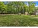 A spacious lawn with various trees and a garden greenhouse in the backyard at 202 Brook Ln, Durham, NC 27712