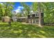 Wide backyard view of a home with dark shutters, green grass and a small greenhouse at 202 Brook Ln, Durham, NC 27712