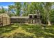 Backyard view featuring a greenhouse, a lush lawn and a house with an attached deck at 202 Brook Ln, Durham, NC 27712