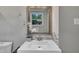 Vanity with stylish mirror, modern sink, decorative plants, and natural light from the window at 202 Brook Ln, Durham, NC 27712