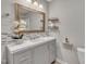 Stylish bathroom featuring a marble countertop, decorative mirror, and modern fixtures at 202 Brook Ln, Durham, NC 27712