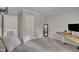 Neutral bedroom featuring a mirror, wood desk, and a view into the next room at 202 Brook Ln, Durham, NC 27712