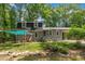 Charming gray home featuring a covered hammock area and lush greenery at 202 Brook Ln, Durham, NC 27712