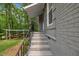 Exterior steps leading to a side entrance, accented by a black railing and brick facade at 202 Brook Ln, Durham, NC 27712