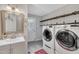 Convenient laundry area featuring washer, dryer, shelving, sink, and door to the backyard at 202 Brook Ln, Durham, NC 27712