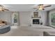 Bright living room showcasing a white brick fireplace and a ceiling fan at 202 Brook Ln, Durham, NC 27712