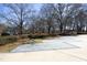 Wide concrete driveway with brick accents flanked by mature trees and lush landscaping leads to a beautiful property at 203 Edinburgh Dr # C, Cary, NC 27511