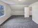 Cozy bedroom featuring carpeted flooring, a window, and a door, offering a quiet retreat within the home at 205 Dwelling Pl, Knightdale, NC 27545
