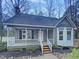 Charming gray home featuring a cozy porch with white railings and a beautifully landscaped front yard at 205 Dwelling Pl, Knightdale, NC 27545