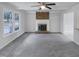 Bright living room with a brick fireplace, ceiling fan, and large window at 205 Dwelling Pl, Knightdale, NC 27545