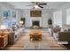 Bright, staged living room features a cozy brick fireplace, ceiling fan, and neutral decor at 205 Dwelling Pl, Knightdale, NC 27545