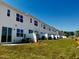Exterior view of new construction townhomes featuring individual patios and newly seeded lawn at 26 Twin Birch Dr, Angier, NC 27501