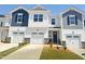 New townhome shows garages and manicured yards. Two-story home with a covered front porch at 26 Twin Birch Dr, Angier, NC 27501