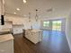 Modern kitchen with white cabinets, stainless steel appliances, a kitchen island, and an open layout to the living area at 26 Twin Birch Dr, Angier, NC 27501