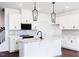 Bright, modern kitchen with a large island, white cabinets, pendant lighting, and stainless appliances at 26 Twin Birch Dr, Angier, NC 27501