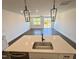 Modern kitchen island with stainless steel sink and fixtures overlooking the open-concept living area at 26 Twin Birch Dr, Angier, NC 27501