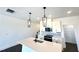 Close-up view of a kitchen island with quartz countertops, black fixtures, and modern pendant lighting at 26 Twin Birch Dr, Angier, NC 27501