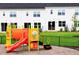 Community playground with colorful play structures, nestled next to modern townhomes at 26 Twin Birch Dr, Angier, NC 27501