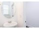Neutral powder room featuring a modern round mirror and pedestal sink at 26 Twin Birch Dr, Angier, NC 27501