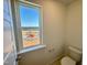 Well-lit powder room featuring a window with playground view and a modern toilet at 26 Twin Birch Dr, Angier, NC 27501