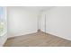 Bright bedroom with light wood flooring, a window, and a door with white trim at 273 Marvel Dr # 139, Rolesville, NC 27571