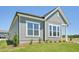 Attractive gray exterior of a new home with neatly landscaped yard, bright windows, and clear blue skies above at 273 Marvel Dr # 139, Rolesville, NC 27571