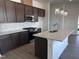 A kitchen featuring an island with quartz countertops, stainless appliances, and dark cabinets at 273 Marvel Dr # 139, Rolesville, NC 27571