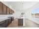 Stylish kitchen featuring wood cabinets, an island with a sink, pendant lighting, and modern stainless steel appliances at 273 Marvel Dr # 139, Rolesville, NC 27571