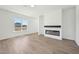 Bright living space with durable wood flooring, a modern fireplace, and a large window overlooking the outdoors at 273 Marvel Dr # 139, Rolesville, NC 27571