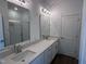 Bathroom featuring double sink vanity with quartz countertops, large mirrors, and a glass-enclosed shower at 2880 Quarry Rd # 163, Rolesville, NC 27571