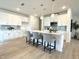 Kitchen boasts a large island with seating, white cabinetry, and a stylish backsplash at 2880 Quarry Rd # 163, Rolesville, NC 27571