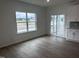 Bright living area with luxury vinyl plank flooring and view of screen door porch and neighborhood at 2880 Quarry Rd # 163, Rolesville, NC 27571