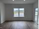 Bright living room with hardwood floors, large window, and sliding glass door to a patio at 2880 Quarry Rd # 163, Rolesville, NC 27571