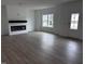 Open living area with modern electric fireplace, large window, luxury vinyl plank flooring, and neutral colors at 2880 Quarry Rd # 163, Rolesville, NC 27571