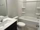 Bright bathroom features a shower-tub combo, dark vanity and a large mirror at 3009 Honeymyrtle Ln, Durham, NC 27703
