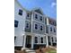 Charming townhome with gray and white siding, black door and window trim, and stone accents near the front entrance at 3009 Honeymyrtle Ln, Durham, NC 27703