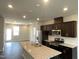 Open kitchen with a large granite island, dark cabinetry, and stainless steel appliances for a modern feel at 3009 Honeymyrtle Ln, Durham, NC 27703