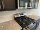 Close-up of a modern gas range with stainless steel appliances and granite countertops for a chef-inspired space at 3009 Honeymyrtle Ln, Durham, NC 27703