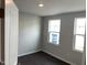 Bedroom with two windows and neutral walls, offers natural light and wood-look flooring at 3011 Honeymyrtle Ln, Durham, NC 27703