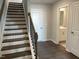 Inviting entryway with hardwood floors, staircase featuring dark wood steps and banister, and a half-bath visible at 3011 Honeymyrtle Ln, Durham, NC 27703