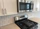 Close up of kitchen featuring stainless steel appliances, white subway tile backsplash and quartz countertops at 3011 Honeymyrtle Ln, Durham, NC 27703