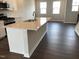 New kitchen island with stainless steel sink and quartz countertops overlooking a sunlit dining area at 3011 Honeymyrtle Ln, Durham, NC 27703