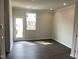 Bright living area with dark hardwood floors and a door to the outside deck at 3011 Honeymyrtle Ln, Durham, NC 27703