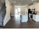 Open-concept living room flowing into the kitchen with white cabinets and a center island, and modern appliances at 3011 Honeymyrtle Ln, Durham, NC 27703