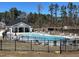 Exterior of a community pool featuring a gated area with lounge chairs, umbrellas, and a covered pavilion for residents enjoyment at 3011 Honeymyrtle Ln, Durham, NC 27703