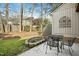 Backyard featuring a concrete patio with a metal table and chair set, surrounded by lush greenery at 308 Summerfield Crossing Road, Chapel Hill, NC 27514