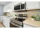 Up close view of stainless steel oven and microwave in white kitchen at 308 Summerfield Crossing Road, Chapel Hill, NC 27514