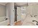 Bright bathroom boasts double vanity, soaking tub, walk-in shower, and an open door at 309 Neuse Ridge Dr, Clayton, NC 27527