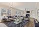 Bright living room with large windows, modern chandelier, fireplace, hardwood floors and stylish furniture and decor at 309 Neuse Ridge Dr, Clayton, NC 27527