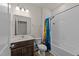 Bathroom featuring a dark vanity, framed mirror, toilet, and a bathtub with a shower at 3413 Dragonfly River Ct, Raleigh, NC 27604